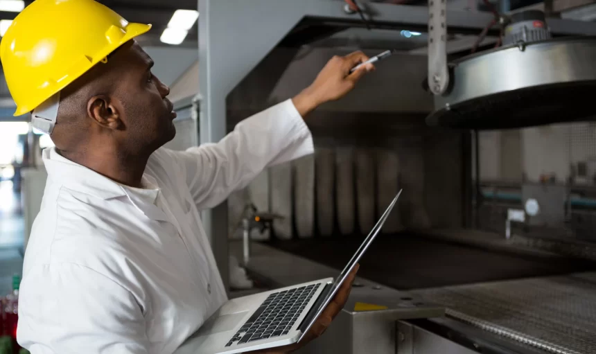 male-worker-wearing-lab-coat-while-using-laptop
